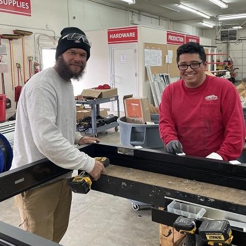 two apprentices work together in a shop