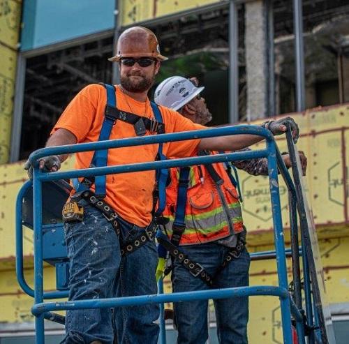 Two glaziers stand on a lift