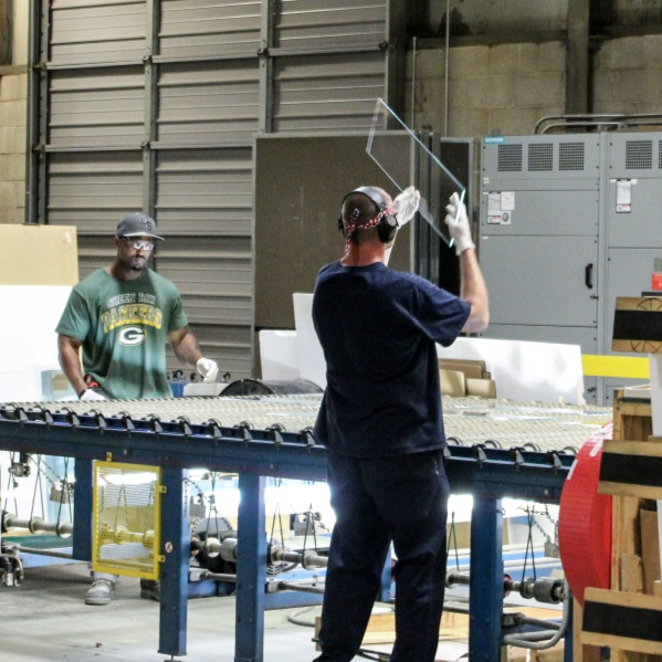 two workers on glass fabrication line